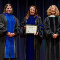 Awardee posing with award, with Christine and Provost Drake